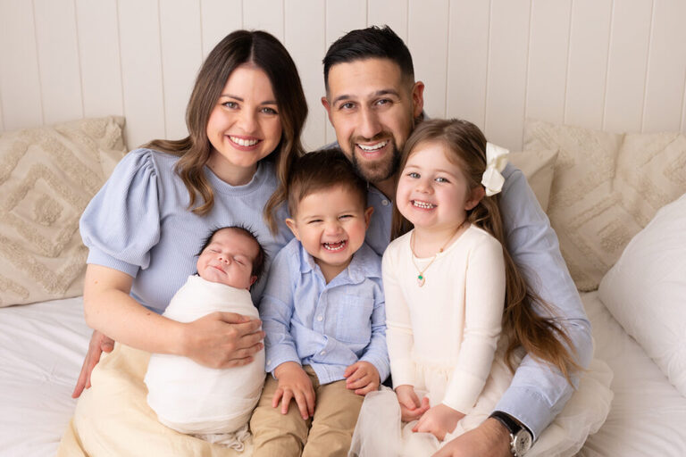 Family portrait with parents, siblings and their newborn baby in the studio